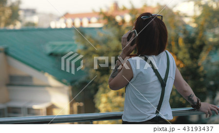 Young redhaired woman riding bicycle in city. Woman with mobile phone 43193437