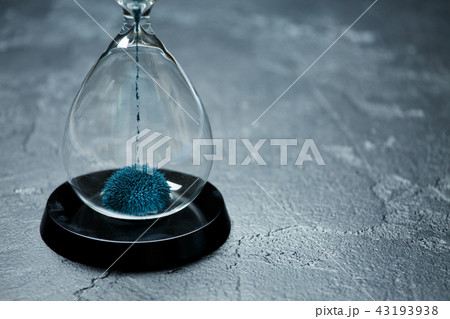 Image of hourglass with blue sand on black stone background, Image of hourglass with blue sand on black stone background, 43193938