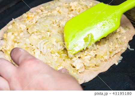 spreading of stuffing on sheet of dough 43195180