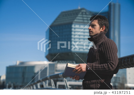 Young man studen reading book outdoors in sunny day 43197251