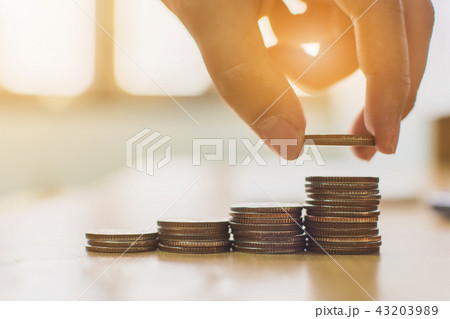 Hand putting coin stack step staircase on desk 43203989