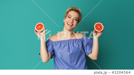 Portrait of pretty woman with grapefruit at blue background Portrait of pretty woman with grapefruit at blue background 43204564