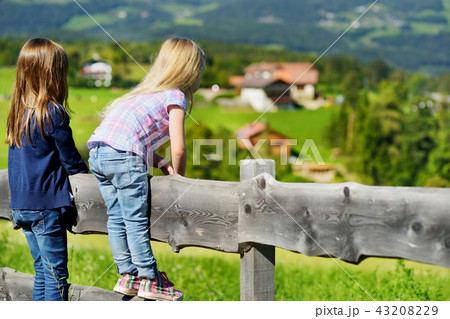Two sisters admiring landscape in Dolomites Two sisters admiring landscape in Dolomites 43208229
