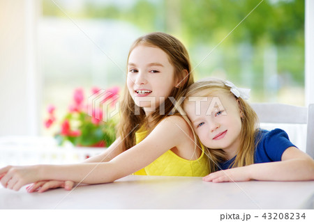 Portrait of two cute little sisters at home  43208234