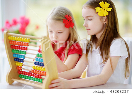 Two cute little girls playing with abacus at home 43208237