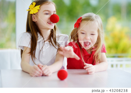 Happy little sisters wearing red clown noses 43208238