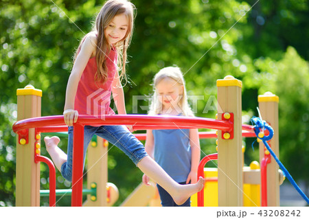 Two cute little girls having fun on a playground 43208242