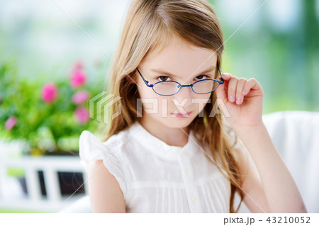 Portrait of cute little girl wearing glasses at home. Vision, health, ophthalmology concept. Portrait of cute little girl wearing glasses at home. Vision, health, ophthalmology concept. 43210052