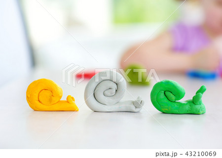 Cute little girl having fun with modeling clay at a daycare. Creative kid molding at home. Cute little girl having fun with modeling clay at a daycare. Creative kid molding at home. 43210069