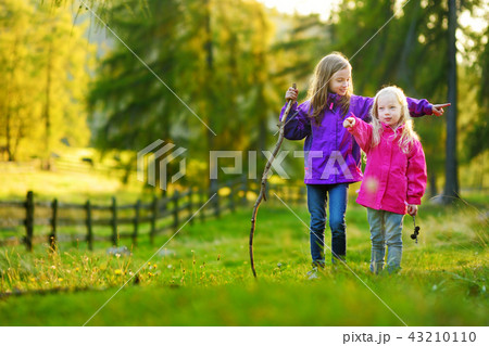 Two funny sisters having fun during forest hike Two funny sisters having fun during forest hike 43210110