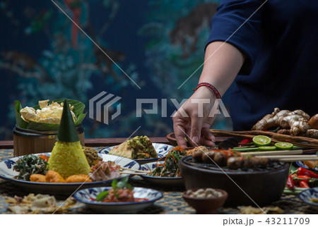Waiter is serving table with different dishes.  43211709