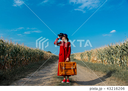 Young girl in coat with suitcase and binoculars  43216206