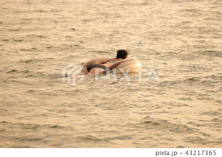 Real woman swimming with inflatable ring in sea, copyspace 43217365