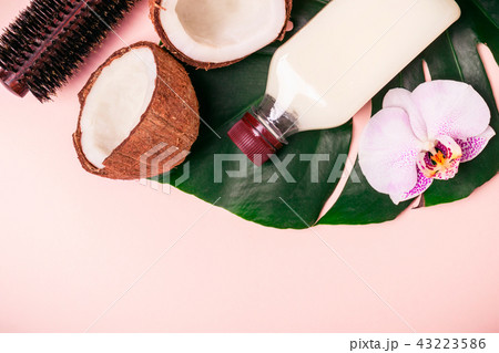 Coconut oil and halves of fresh coconut on a pink background. Hair care spa concept 43223586