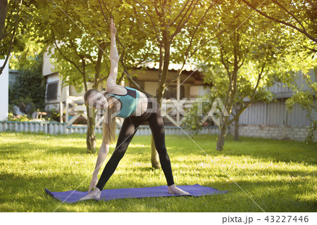 Woman in the garden practices yoga 43227446