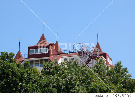A multi-storey house with a red roof made of shingles 43229450