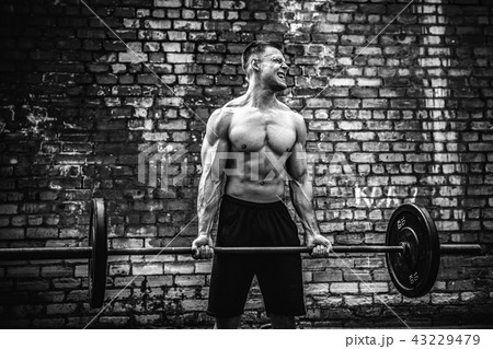 Muscular fitness man doing deadlift a barbell over his head in outdoor, street gym. Functional 43229479