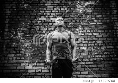 Fitness man exercising with stretching band in outdoor gym. Fitness man exercising with stretching band in outdoor gym. 43229768