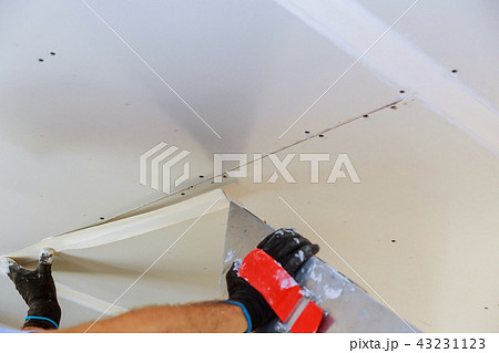 Hand with a spatula plaster on a wall Hand with a spatula plaster on a wall 43231123