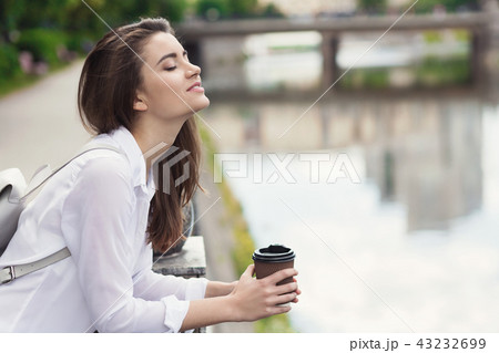 Young beautiful girl standing near city waterfront Young beautiful girl standing near city waterfront 43232699