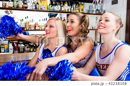 Group of cheerleader girls watching a game of their favorite tea 43238108