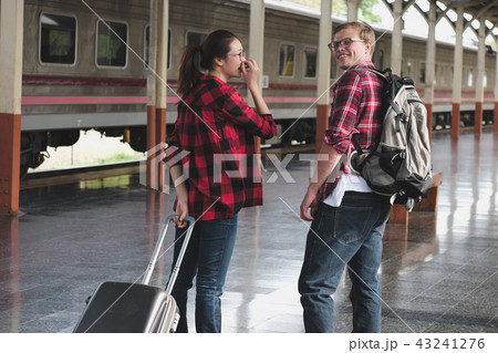 man & woman with backpack & baggage waiting for train at railway station. loving couple traveler travel together on holiday man & woman with backpack & baggage waiting for train at railway station. loving couple traveler travel together on holiday 43241276