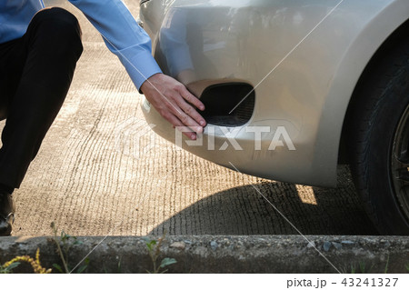 male agent examining car damaged by traffic accident. caucasian man filling auto insurance form. male agent examining car damaged by traffic accident. caucasian man filling auto insurance form. 43241327