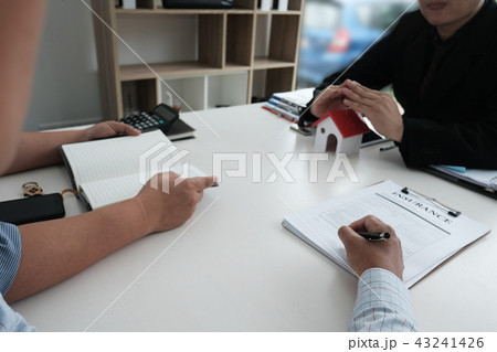 hand protecting house model. client signing home insurance contract. property safety & security concept hand protecting house model. client signing home insurance contract. property safety & security concept 43241426