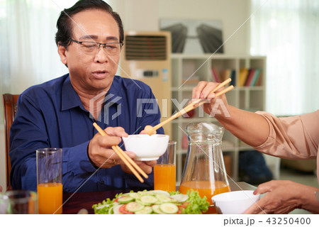 Senior man at dinner table 43250400