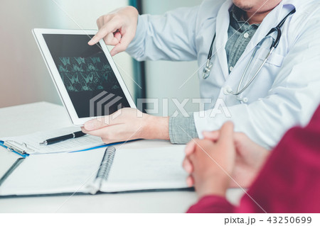 Doctor consulting with patient results x-ray film Doctor consulting with patient results x-ray film 43250699