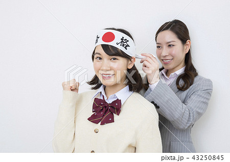 受験イメージ　鉢巻きを家庭教師に巻いてもらう女子高生 43250845