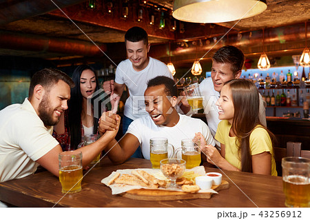 Two handsome male friends having arm wrestling challenge at bar. 43256912