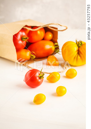 Bright tomatoes in a paper bag, white background. Bright tomatoes in a paper bag, white background. 43257793
