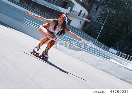 Beautiful girl is riding in rollers in skate park. She is doing that very active. She is happy. 43266052