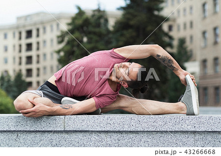 Man doing yoga stretching exercise in the city Man doing yoga stretching exercise in the city 43266668