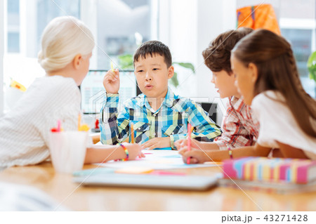 Smart schoolboy telling a story to his classmates Smart schoolboy telling a story to his classmates 43271428
