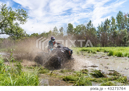 ATV Quad rides fast on big dirt and makes splashes of dirty water ATV Quad rides fast on big dirt and makes splashes of dirty water 43273764