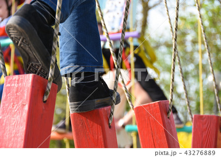 Feet of the child step on the hanging logs 43276889