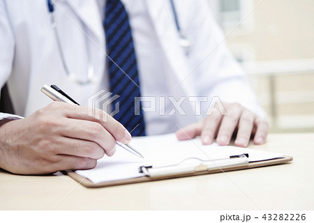 Closeup hand using pen to sign on paper in office. 43282226