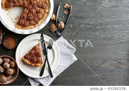 Traditional walnut pie with spices and nuts on dark wooden table Traditional walnut pie with spices and nuts on dark wooden table 43283558