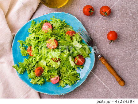 Salad with cherry tomatoes on blue plate 43284297