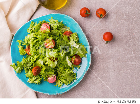Salad with cherry tomatoes on blue plate 43284298