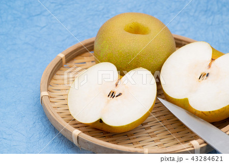 ナシ ザルに盛られた2個 カットあり 水色の背景 B やや上からの写真素材