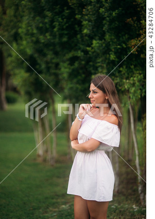 young and pretty girl in a summer city standing near the tree 43284706