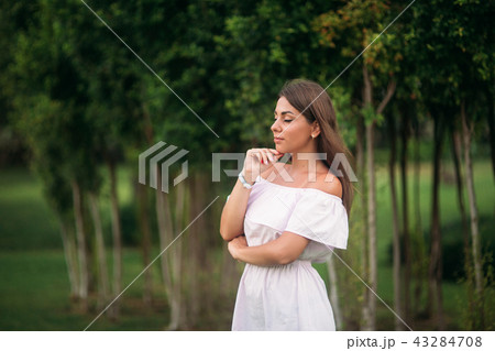 young and pretty girl in a summer city standing near the tree 43284708