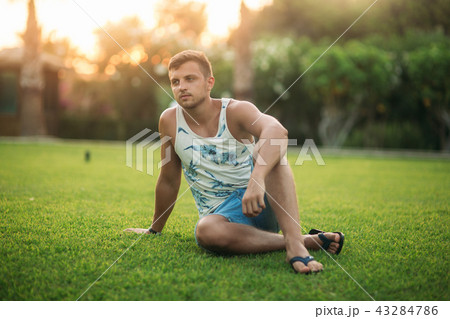 Smiled man in shorts and shirt in summer time walks near the park 43284786