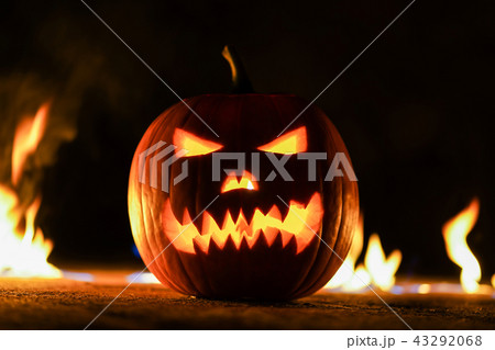 Terrifying symbol of Halloween - Jack-o-lantern. Scary broken head of pumpkin in inferno fire flames Terrifying symbol of Halloween - Jack-o-lantern. Scary broken head of pumpkin in inferno fire flames 43292068