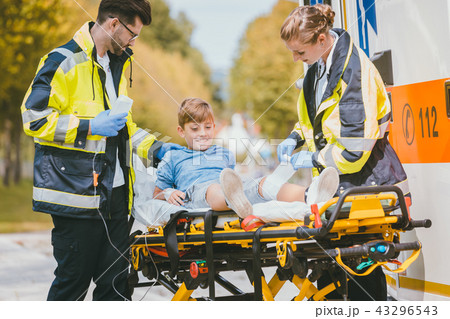 Medics putting injured boy on stretcher after accident Medics putting injured boy on stretcher after accident 43296543