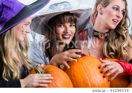 Three beautiful women acting as witches joining their malicious forces Three beautiful women acting as witches joining their malicious forces 43296559