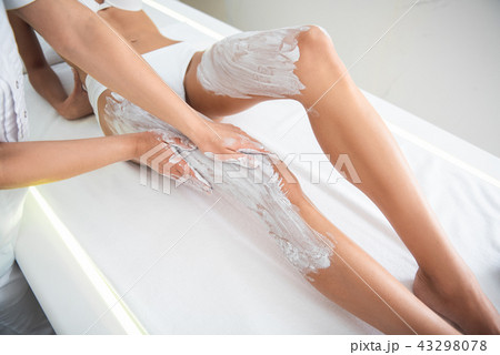 Young woman having therapeutic massage with white clay 43298078
